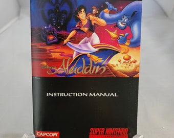 May include: A Super Nintendo Entertainment System instruction manual for the Disney's Aladdin video game. The cover features Aladdin, Abu, and Genie flying on a magic carpet.