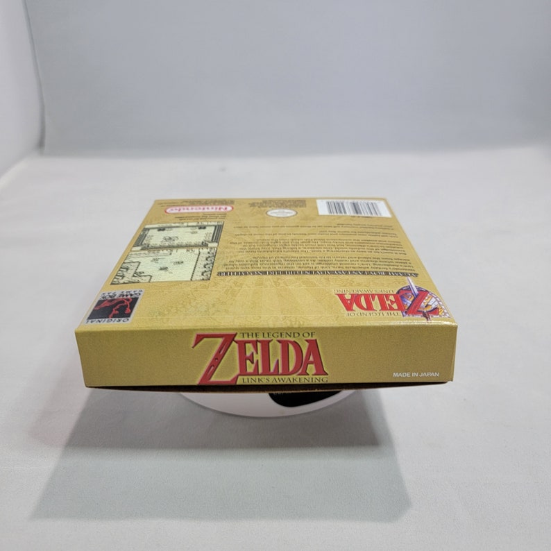 May include: A gold Nintendo Game Boy Color game cartridge case for The Legend of Zelda: Link's Awakening. The case has a picture of Link on the front and the game title on the back. The case is made in Japan.