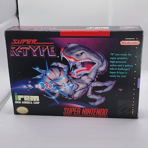 May include: Super R-Type video game cartridge box art for the Super Nintendo Entertainment System. The box art features a menacing, grey, alien creature with a large, red mouth and sharp teeth. The creature is holding a spaceship in its claws. The text "Super R-Type" is in red and white letters. The text "irem" is in white letters. The text "Super Nintendo" is in white letters.