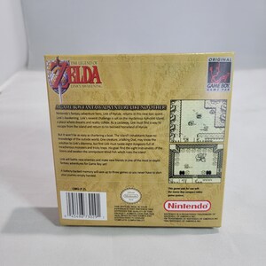 May include: The Legend of Zelda: Link's Awakening Game Boy game cartridge box art. The box is brown with gold accents and features a picture of Link on the front. The back of the box has a description of the game and a picture of the game screen. The box is in good condition.