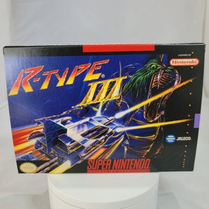 May include: A Super Nintendo Entertainment System game cartridge for R-Type III, featuring a black and blue background with a silver spaceship and a green monster with a yellow mouth. The game is licensed by Nintendo and published by Jaleco.