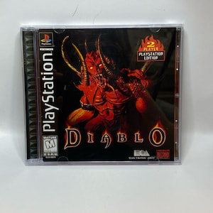 Peut inclure: Bo&icirc;tier de jeu PlayStation pour Diablo. La couverture pr&eacute;sente un d&eacute;mon rouge avec des cornes et le titre du jeu dans une police stylis&eacute;e. Le bo&icirc;tier est &eacute;tiquet&eacute; "2 Player PlayStation Edition".