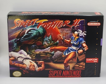 May include: A Super Nintendo Entertainment System game cartridge for Street Fighter II. The box art features a green and red character with a fierce expression, kicking a female character in a blue and white outfit. The game is licensed by Nintendo and published by Capcom.