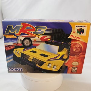 Peut inclure: Une voiture de course jaune, violette et noire sur une boîte bleue et orange avec le texte "MRC Multi-Racing Championship" et "Ocean" sur le devant. La boîte est pour un jeu vidéo Nintendo 64.