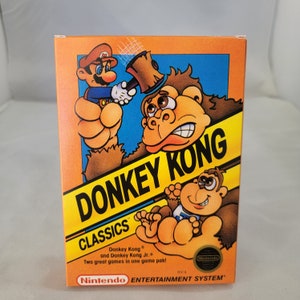 May include: A retro Nintendo Entertainment System game box for Donkey Kong Classics. The box features colourful illustrations of Mario, Donkey Kong, and Donkey Kong Jr. The game title is in large yellow letters with a black outline. The Nintendo logo is visible.