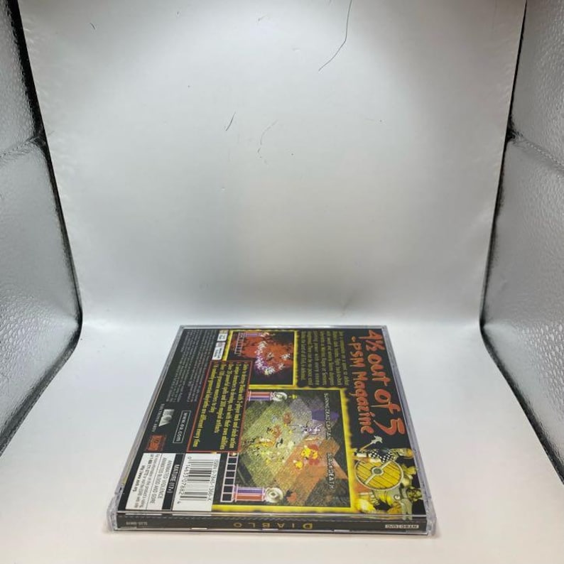 Peut inclure: Un bo&icirc;tier en plastique transparent contenant le jeu vid&eacute;o Diablo pour Playstation. Le bo&icirc;tier du jeu pr&eacute;sente une couverture color&eacute;e avec le titre du jeu et des captures d'&eacute;cran. Le texte "4 1/2 Out of 5 - PSM Magazine" est &eacute;galement visible.