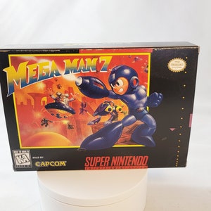 May include: A black Mega Man 7 Super Nintendo game box. The box art shows a blue robot character with a cannon arm, set against a fiery background. The Capcom logo and Super Nintendo logo are visible.