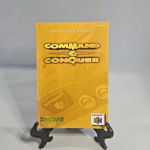 May include: A yellow instruction booklet for the Nintendo 64 video game Command & Conquer. The booklet features the game's logo and the Nintendo 64 logo. The booklet is made by Westwood Studios.