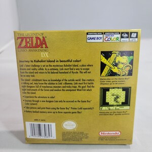 May include: The Legend of Zelda: Link's Awakening DX Game Boy Color game cartridge box art. The box is yellow with a gold border and features a picture of Link on the front. The back of the box has a description of the game and information about the Game Boy Color system.