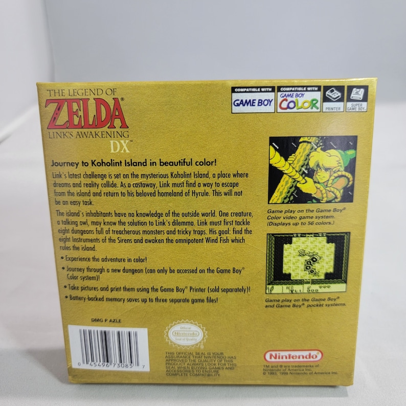 May include: The Legend of Zelda: Link's Awakening DX Game Boy Color game cartridge box art. The box is yellow with a gold border and features a picture of Link on the front. The back of the box has a description of the game and information about the Game Boy Color system.