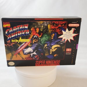 May include: A Super Nintendo Entertainment System game cartridge for Captain America and the Avengers. The box art features Captain America, Iron Man, and other Avengers characters fighting a group of villains. The game is licensed by Nintendo and Marvel Comics.