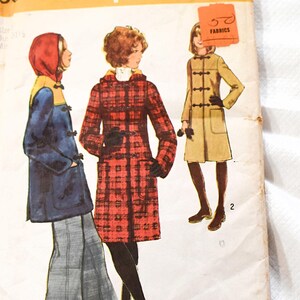 May include: Vintage Simplicity sewing pattern number 5303 for a coat. The pattern shows three women wearing different versions of the coat. The coat is a knee-length, double-breasted style with a hood. The pattern is priced at $1.00.