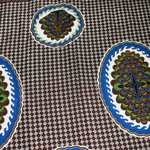 May include: Brown and white fabric with a repeating diamond pattern. The fabric features three blue and white circles with a brown, green, and blue design inside each circle.