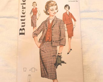 Può includere: Una busta per cartamodello Butterick 2433 per taglia 16, busto 36 pollici. La copertina presenta illustrazioni di un completo gonna e giacca a quadri, un gilet a tinta unita e un completo gonna e giacca a tinta unita. Testo: Butterick, 2433, 10 12 14 16 18.