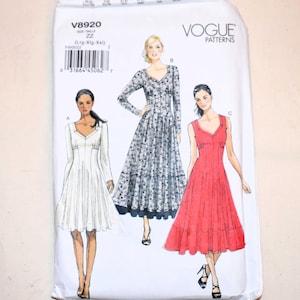 Puede incluir: Paquete de patrones de costura Vogue Patterns. El paquete presenta ilustraciones de tres diseños de vestidos diferentes. El paquete es blanco con el texto "V8920" y "VOGUE PATTERNS". Los diseños de vestidos incluyen un vestido blanco, un vestido estampado y un vestido rojo.