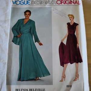 May include: Vogue Designer Original sewing pattern number 2312 for a long dress with a cowl neck and a matching jacket. The pattern is for a dress with a fitted bodice and a flowing skirt. The dress is shown in a teal green color and the jacket is shown in a burgundy color.
