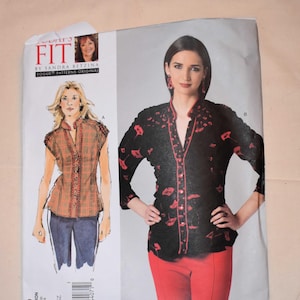 Puede incluir: Patrón de costura Vogue Patterns Original V1260. El patrón presenta ilustraciones de una blusa con cuello y una mujer que lleva una blusa negra con detalles rojos y pantalones rojos. Incluye todas las tallas.