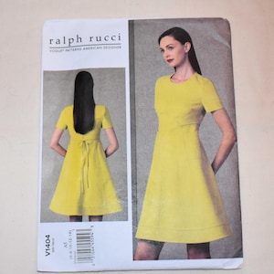 Puede incluir: Un patrón de costura para un vestido de Ralph Rucci. El patrón presenta un vestido amarillo con mangas cortas y una falda acampanada. La parte delantera del patrón muestra a una modelo que lleva el vestido, y la parte trasera muestra el vestido con un lazo.