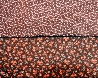 May include: Two fabric swatches. The top swatch is a dark brown with a pattern of small white dots. The bottom swatch is dark brown with a floral pattern of pink, blue, and white flowers.