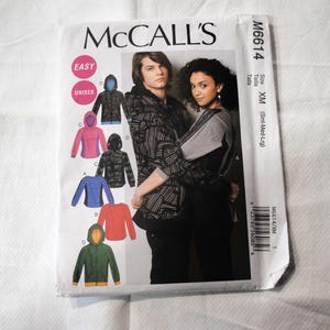 May include: McCall's sewing pattern for unisex hoodies. The pattern features multiple hoodie designs in various colors, including blue, pink, and green. The pattern is labeled "EASY" and includes size information.