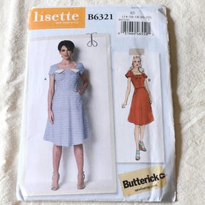 May include: A Lisette B6321 Butterick sewing pattern envelope featuring two dress designs. View A shows a blue patterned dress with a white collar and short sleeves. View B shows a solid rust-colored dress with short sleeves. The envelope includes a barcode.