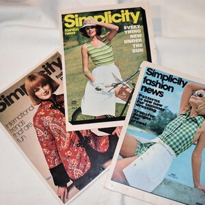May include: Three vintage Simplicity fashion news magazines. The covers feature models in summer clothing, with text like "EVERYTHING NEW UNDER THE SUN" and "Patterns to sew now for summer dressing". The magazines are on a white surface.