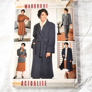 Puede incluir: Un patrón de costura Butterick vintage titulado "Today's Wardrobe". La portada presenta imágenes de mujeres modelando varios conjuntos, incluyendo un abrigo largo azul marino, un traje y un vestido. El texto "TENUES ACTUALITÉ" es visible.