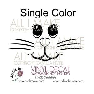 May include: Black and white single color vinyl decal of a cat face with large eyes, a heart-shaped nose, and whiskers. The decal says "ALL I MAKE COPYRIGHT CAMILLA HOKE" at the top and bottom.