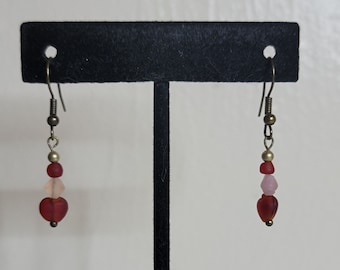 Boucles d'oreilles pendantes faites main avec des perles rouges et roses.