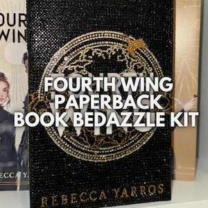 Peut inclure: Une couverture de livre noire avec un motif de globe terrestre en or et argent. Le texte "FOURTH WING PAPERBACK BOOK BEDAZZLE KIT" est imprimé en blanc sur la couverture. Le nom de l'auteur, "REBECCA YARROS", est imprimé en or en bas de la couverture.