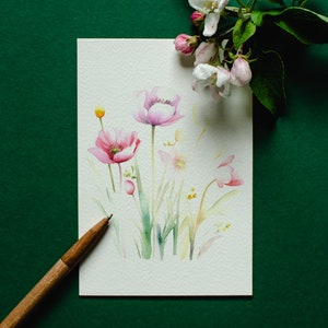 May include: A watercolor painting of pink flowers with green stems and leaves on a white background. The painting is on a green surface with a wooden pencil.