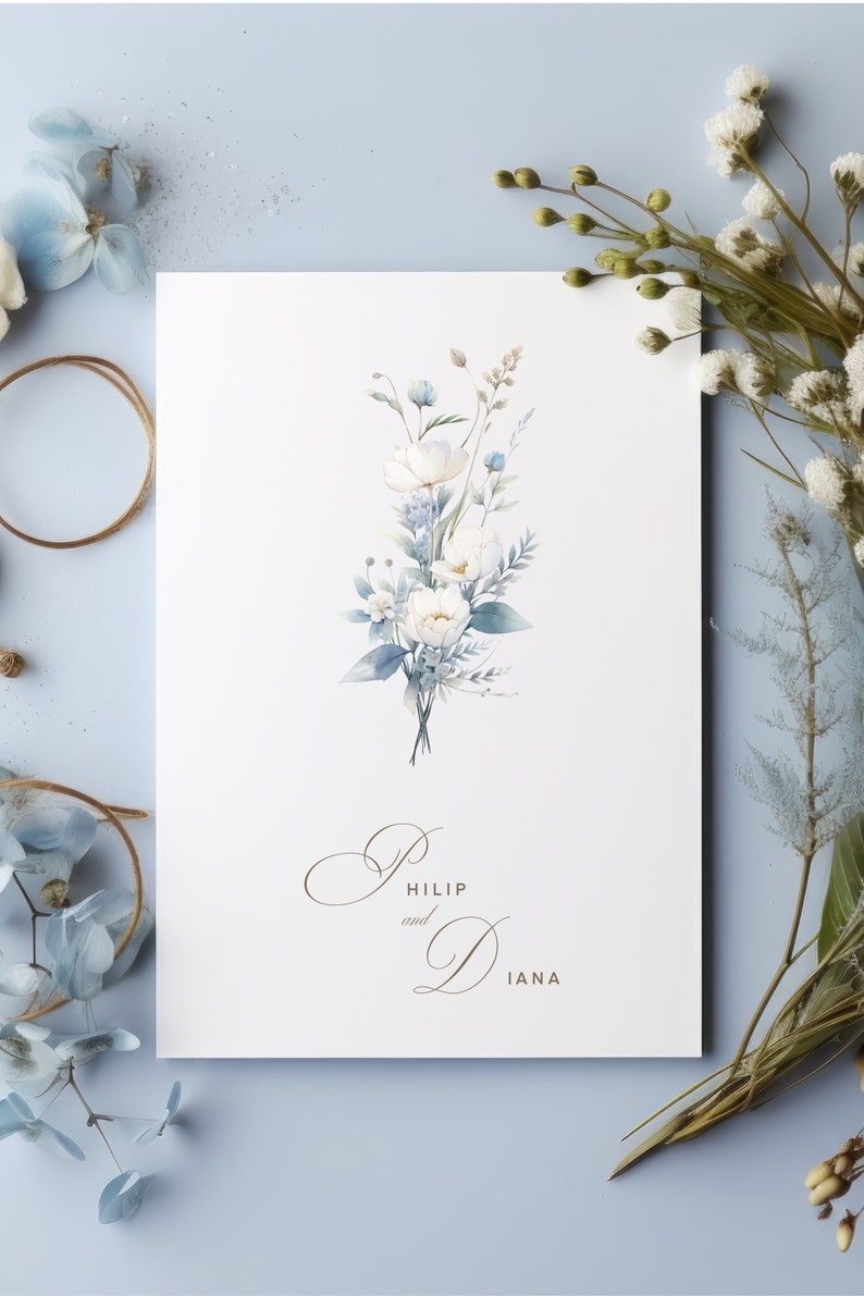 May include: A white card with a watercolour illustration of a bouquet of white flowers with blue accents. The text "Philip and Diana" is printed in gold script at the bottom of the card.