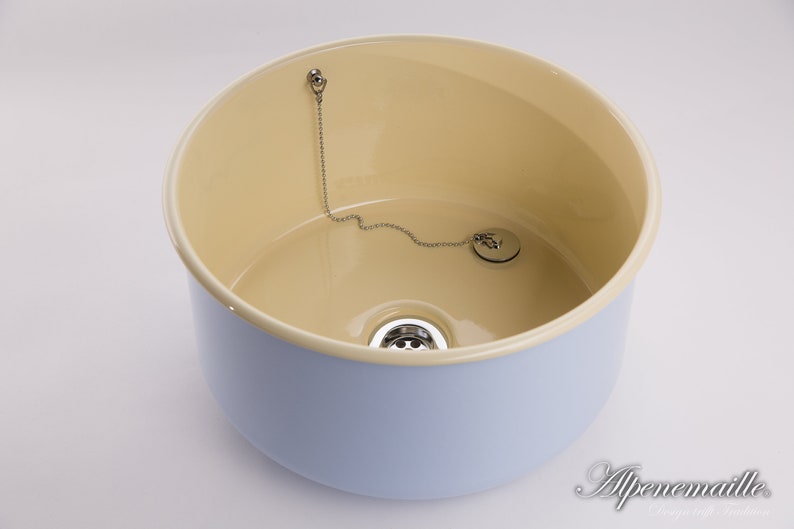 K&ouml;nnte beinhalten: Ein hellblaues Keramik-K&uuml;chensp&uuml;lbecken mit cremefarbenem Innenraum. Das Sp&uuml;lbecken hat einen Abfluss und eine Kette, die an einem Stopfen befestigt ist.