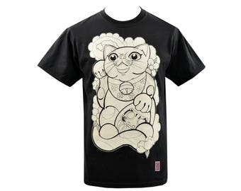 May include: Black t-shirt featuring a cream-colored illustration of a Japanese Maneki Neko cat. The cat is depicted with a bell collar and floral accents. The design is centered on the front of the shirt.