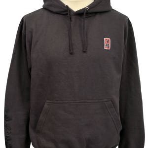 May include: A dark gray hooded sweatshirt with a small red square patch on the chest that says "三福" in black lettering. The sweatshirt has a kangaroo pocket and a drawstring hood.