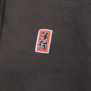 May include: A dark gray hoodie with a red and white square patch featuring Japanese characters. The characters are "三福" which translates to "Three Blessings".
