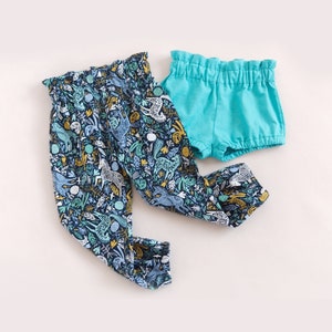 Flat lay of kids paper bag pants and shorts made from cotton fabric and linen