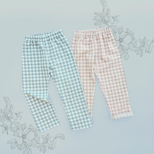 Puede incluir: Dos pantalones con cintura elástica, uno con un patrón de cuadros vichy en azul claro y blanco y el otro con un patrón de cuadros vichy en rosa claro y blanco, ambos con corte de pierna recta y un acabado de dobladillo simple.