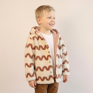 Step-by-step kids coat sewing pattern displayed with finished reversible jacket.