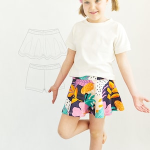 Può includere: Una t-shirt bianca a maniche corte e una gonna con base blu scuro caratterizzata da una colorata stampa tropicale con fiori rosa, ananas arancioni e foglie verdi. Accanto alla gonna, un disegno al tratto in bianco e nero mostra gonna e shorts.