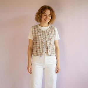 Reversible Women's Vest Sewing Pattern PDF shown on the women with white t-shirt and white pants.