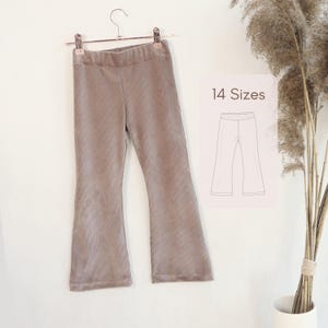 Puede incluir: Pantalones de pana color topo con silueta de pierna acampanada y cintura elástica, colgados de una percha de metal. Una superposición gráfica muestra un dibujo lineal de los pantalones con el texto 14 Sizes impreso sobre la ilustración.