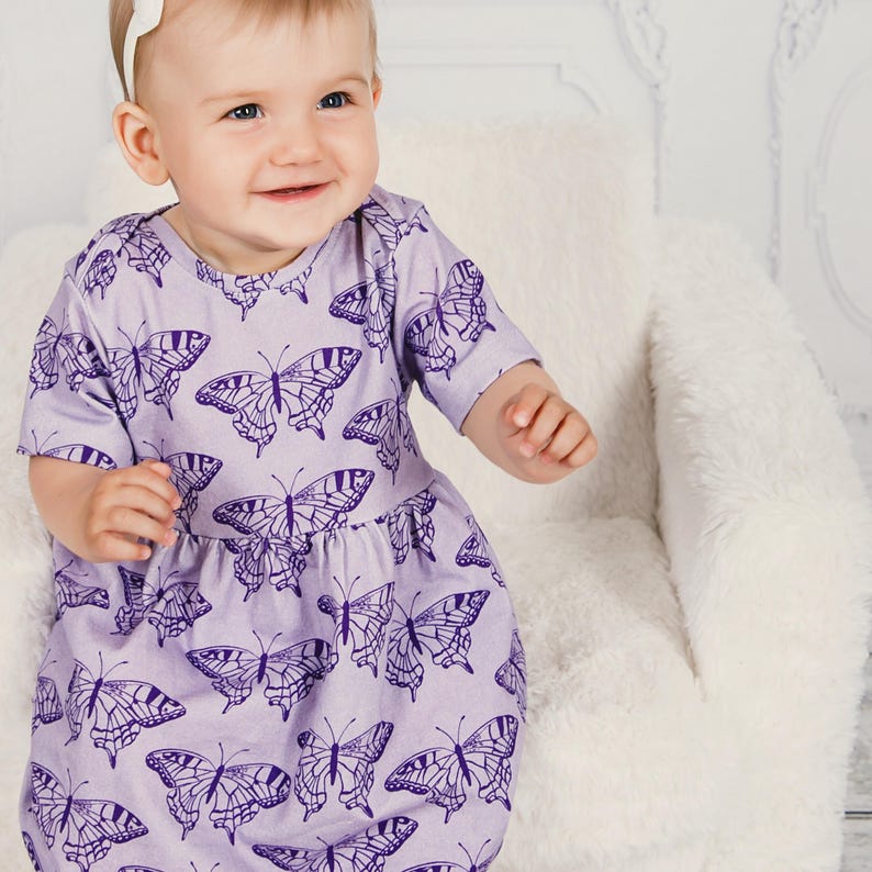 Baby girl wearing a simple handmade dress sewn from a beginner PDF sewing pattern.
