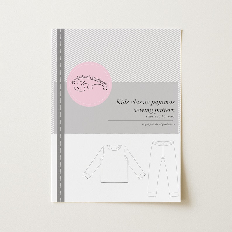 May include: A sewing pattern document for kids classic pajamas in sizes 2 to 10 years. The cover features a pink circular logo with the text MadeByMePatterns, a grey and white striped background, and a line drawing of a long-sleeve top and pants.