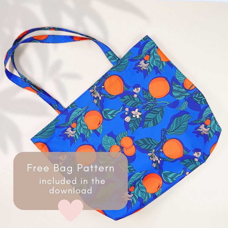 May include: Blue tote bag with a vibrant orange and floral pattern. The bag features a repeating design of oranges, green leaves, and white blossoms. The text "Free Bag Pattern included in the download" is visible on the bag.