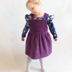 Adjustable back strap options on kids pinafore dress sewing pattern – cross-back or straight-back style.