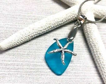 May include: A turquoise sea glass pendant necklace with a silver starfish charm. The necklace is on a white starfish background.