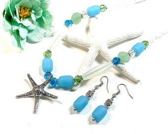 May include: A light blue and green beaded necklace with a silver starfish pendant and matching light blue beaded earrings.