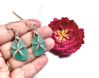 May include: A pair of silver dangle earrings with teal sea glass and silver starfish charms.