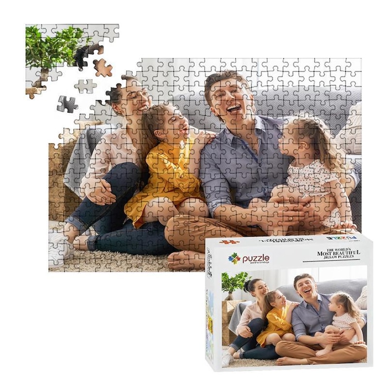 Puede incluir: Un rompecabezas que representa a una familia riendo junta, con algunas piezas ensambladas y otras dispersas. La caja del rompecabezas muestra la imagen completa y dice "THE WORLD'S MOST BEAUTIFUL JIGSAW PUZZLES."